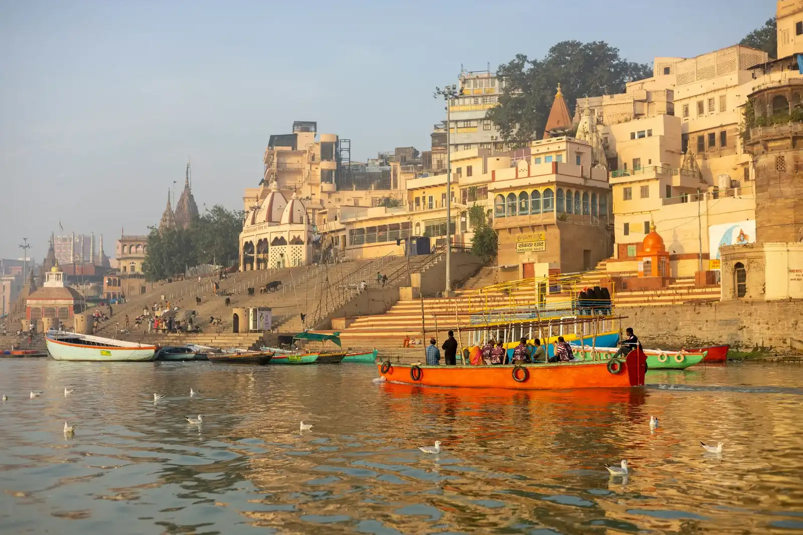 Colorful boats on the Ganga river at Varanasi ghats in golden morning light
